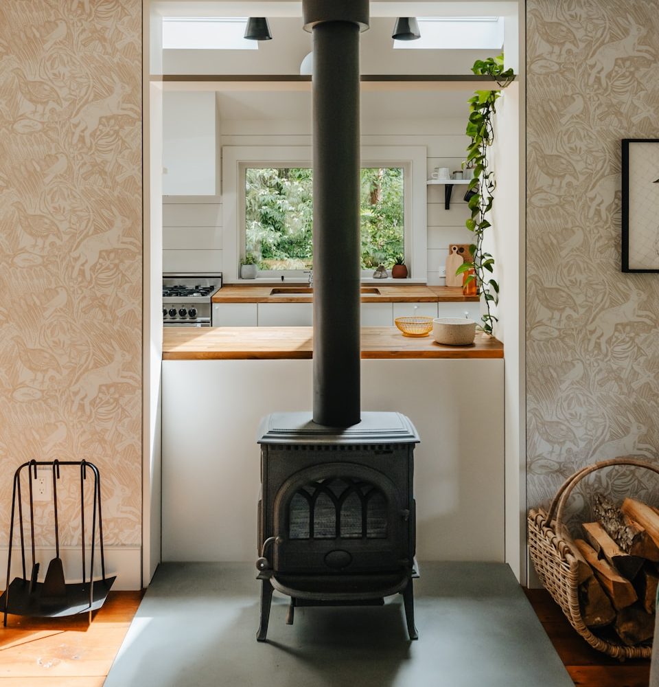 A black stove in a kitchen next to a window