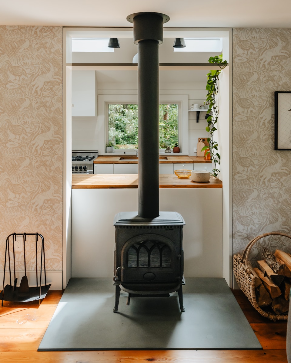 A black stove in a kitchen next to a window